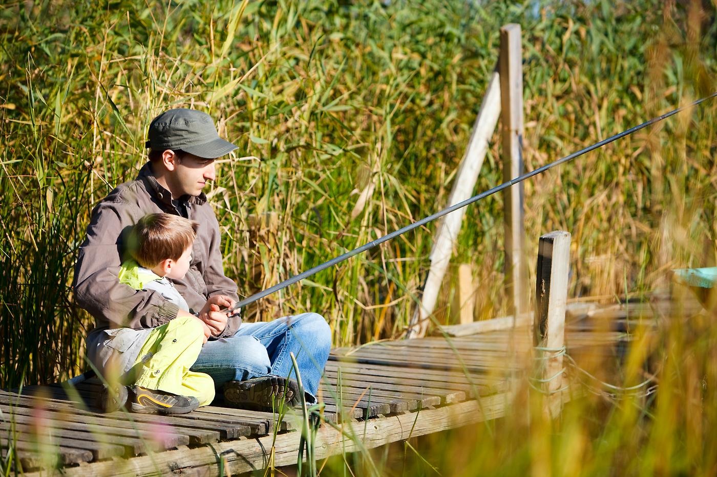 Pappa och barn som fiskar.