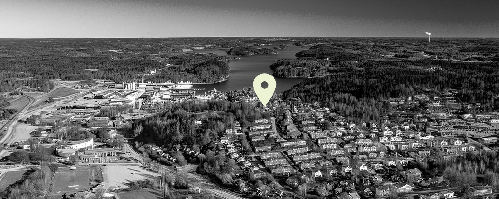Flygfoto över en svensk bygd med kartnål mitt i bilden., AI-genererad